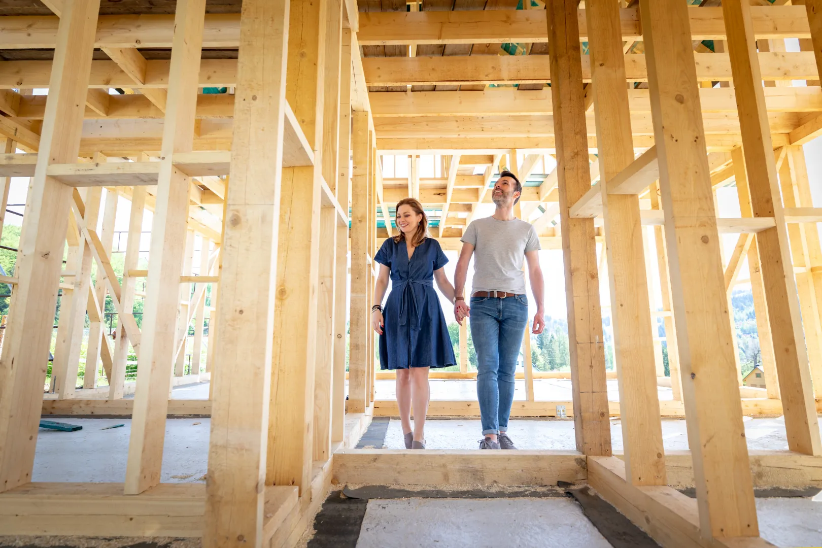 A couple inside the wood-framed shell of a new home under construction